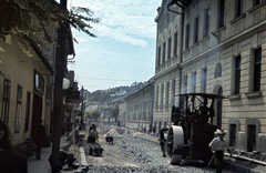 Magyarország, Budapest XXII., Kossuth Lajos utca, jobbra a polgári iskola (később Kossuth Lajos Magyar–Angol Két Tanítási Nyelvű Általános Iskola)., 1942, Szőke Annamária/Anonime, színes, útépítés, talicska, úthenger, Budapest, Fortepan #61670