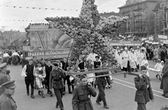 Magyarország, Budapest XIV.,Budapest VII., a mai Ötvenhatosok tere (Sztálin tér), május 1-i felvonulás, háttérben a Dózsa György út épületei., 1956, Magyar Rendőr, egyenruha, orvos, felvonulás, május 1, népviselet, vörös csillag, propaganda, transzparens, Budapest, Fortepan #67294