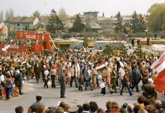 Magyarország, Veszprém, Jutasi (Felszabadulás) út, május 1-i felvonulás, háttérben az autóbusz-pályaudvar., 1980, Joó Sándor, színes, autóbusz, zászló, magyar gyártmány, munkásőr, Ikarus-márka, felvonulás, május 1, Ikarus 55, gyerekek, buszpályaudvar, autóbuszállomás, Ikarus 266, Fortepan #70641