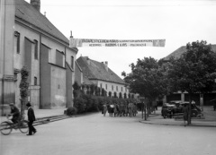 Magyarország, Gyöngyös, Fő (Hanisz) tér, balra a Szent Bertalan-templom. Budapesti Cecilia kórus, középen Bárdos Lajos karnagy., 1941, Lissák Tivadar, templom, csoportkép, útjelző tábla, hirdetmény, kerékpár, Fortepan #71625