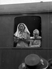 Magyarország, Budapest I., a Déli pályaudvar. Az Országos Gyermekvédő Liga önkéntese és egy nyaralásra induló gyerek., 1942, Lissák Tivadar, ápolónő, diáksapka, vagon, levente, Budapest, ablakon kihajolni, Fortepan #71873