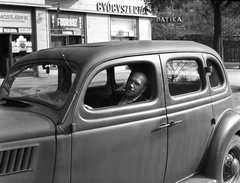 Magyarország, Budapest XIII., Ford V8 Modell 48, 1935-ös kiadású személygépkocsi. Háttérben a Szent István park 26. számú sarokház Pozsonyi út felőli oldala., 1943, Lissák Tivadar, cégtábla, amerikai gyártmány, Ford-márka, sofőr, gyógyszertár, fodrászat, automobil, tejbolt, Ford V8, Budapest, Fortepan #72498