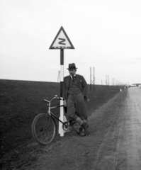 Hungary, főút Szolnok és Szajol között, balra a Tisza gátja., 1935, Lissák Tivadar, bicycle, hat, smoking, pipe, road sign, Fortepan #73119