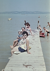 Magyarország, Balatonszárszó, Balaton-part., 1966, Erky-Nagy Tibor, fürdőruha, színes, család, nyaralás, csoportkép, fürdőzés, életkép, gumimatrac, úszógumi, napozás, nyár, csónak, napszemüveg, stég, masni, fecskenadrág, Fortepan #76637