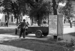 Magyarország, Gödöllő, Szabadság tér., 1976, Berkó Pál, reklám, utcakép, életkép, pótkocsi, hirdetőoszlop, traktor, fasor, pad, Gesztesi József, Fortepan #78404