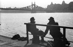 Hungary, Budapest V., Belgrád (Ferenc József) rakpart a nemzetközi hajóállomásnál, háttérben a Szabadság híd budai hídfője., 1946, Berkó Pál, Danube, Budapest, Duna-bridge, János Feketeházy-design, Best of, gentleman, sitting on a handrail, coat, hat, talks, chain, backlight, silhouette, Fortepan #78447