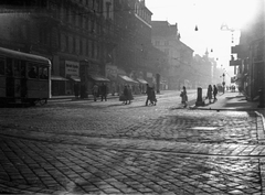 Magyarország, Budapest VIII.,Budapest VII., Rákóczi út, a Nagykörúttól a Baross tér felé nézve, 1940, Berkó Pál, cégtábla, lámpa, villamos, villamosmegálló, Budapest, Fortepan #79479