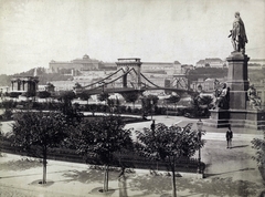 Magyarország, Budapest V.,Budapest I., Széchenyi István (Ferenc József) tér, jobbra Széchenyi István szobra (Engel József, 1880), háttérben a Széchenyi Lánchíd és a Királyi Palota (később Budavári Palota). A felvétel 1880 körül készült. A kép forrását kérjük így adja meg: Fortepan / Budapest Főváros Levéltára. Levéltári jelzet: HU.BFL.XV.19.d.1.06.011, 1900, Budapest Főváros Levéltára / Klösz György fényképei, Klösz György, szobor, Budapest, szoborcsoport, függőhíd, Széchenyi István-ábrázolás, William Tierney Clark-terv, Fortepan #82272