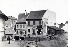 Magyarország, Tabán, Budapest I., Szarvas tér, balra az Apród utca. A felvétel 1894-ben készült. A kép forrását kérjük így adja meg: Fortepan / Budapest Főváros Levéltára. Levéltári jelzet: HU.BFL.XV.19.d.1.08.005, 1900, Budapest Főváros Levéltára / Klösz György fényképei, Klösz György, utcakép, üzletportál, zsalugáter, Budapest, napellenző, Fortepan #82530