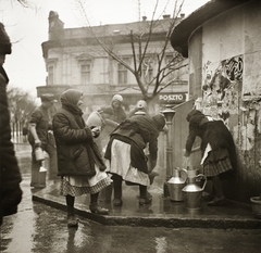 Magyarország, Szeged, Tisza Lajos körút, artézi kút (az Anna-kút elődje), háttérben a Bruckner-ház., 1936, Ebner, plakát, kút, népviselet, kanna, vízhordás, Fortepan #83806