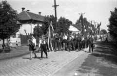 Magyarország, Kisújszállás, Rákóczi utca az Illésy utca felől a Csatorna utca felé nézve., 1960, Morvay Kinga, Morvay Lajos, kerékpár, zászló, felvonulás, fúvószenekar, kockakő, Fortepan #84452