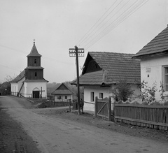 Magyarország, Hollókő, Kossuth utca, Szent Márton templom, jobbra a Petőfi Sándor utca torkolata., 1973, Erdei Katalin, falu, templom, légvezeték, kerítés, templomtorony, Fortepan #85445