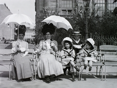 Hungary, Budapest V., Vigadó tér a bérelhető Buchwald székekkel, háttérben a Vigadó épülete., 1909, Schmidt Albin, portrait, hat, sunshades, Frigyes Feszl-design, sailor blouse, Budapest, leg over leg, events' center, Buchwald-chair, Fortepan #86291