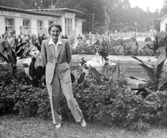 Hungary, Hévíz, a mai Schulfoff Vilmos sétány, háttérben a fürdő bejárati épülete., 1948, Gyöngyi, portrait, fountain, genre painting, lady, sandal, pantsuit, blouse, hands behind the back, Fortepan #8655