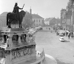 Magyarország, budai Vár, Budapest I., Szentháromság tér, kilátás a Halászbástyáról Szent István szobra (Stróbl Alajos, 1906.) és a Mátyás-templom felé. Szemben a Tárnok utca - Szentháromság utca sarkán a régi budai Városháza épülete., 1968, Gyöngyi, szobor, lovas szobor, Szent István-ábrázolás, Budapest, Fortepan #8725