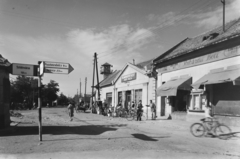 Magyarország, Adony, szemben a Bajcsy-Zsilinszky utca., 1955, UVATERV, egy dunai hajóút, kerékpár, cégtábla, útjelző tábla, utcakép, ruhaüzlet, napellenző, vegyesbolt, Fortepan #91089