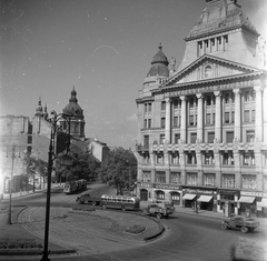 Magyarország, Budapest V.,Budapest VI., Deák Ferenc tér, Anker-ház, balra a háttérben a Szent István-bazilika., 1950, UVATERV, autóbusz, cégtábla, teherautó, villamos, Alpár Ignác-terv, tűzfal, palota, Ikarus 30, eklektikus építészet, Budapest, Csemege vállalat, OTP, fegyver és vadász bolt, Fortepan #9130