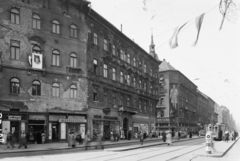 Magyarország, Budapest VIII., Rákóczi út a Baross térről nézve, balra a Berzsenyi Dániel utca torkolata., 1957, UVATERV, cégtábla, életkép, neonreklám, villamos, trafik, fodrászat, csibilámpa, villamosmegálló, Keravill, virágbolt, Budapest, Fortepan #91336