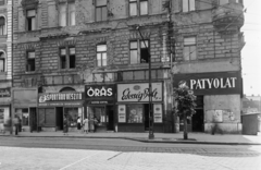 Magyarország, Budapest VIII., Baross tér 4., Fiumei (Mező Imre) út sarok., 1957, UVATERV, kirakat, cégtábla, épületkár, Patyolat Vállalat, órás, Édességbolt, Budapest, Fortepan #91910