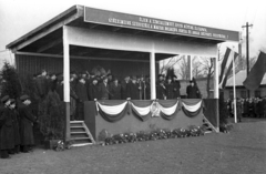 Magyarország, Hatvan, az új vasútállomás avató ünnepsége 1956. január 20-án. A mikrofon mögött Bebrits Lajos közlekedési miniszter., 1956, UVATERV, egyenruha, zászló, ünnepség, mikrofon, címer, szónok, dekoráció, jelmondat, zászlórúd, dísztribün, Fortepan #92050