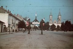 Románia,Erdély, Naszód, diadalkapu a város főterén a magyar csapatok bevonulása idején. Jobbra a görögkatolikus (később ortodox) templom., 1940, Fortepan, területgyarapodás, színes, zászló, horogkereszt, diadalkapu, Fortepan #92559