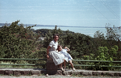 Magyarország, Balatonalmádi, kilátás a hegyoldalról a kikötő felé, balra a rövid oldalon a kenesei löszfal látható., 1961, G K, színes, tó, kislány, gyerek, hölgy, szandál, nyári ruha, kilátás, Fortepan #92837