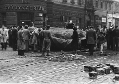 Magyarország, Budapest VIII., Rákóczi út - Nagykörút kereszteződés, a Sztálin-szobor darabolása., 1956, Hofbauer Róbert, kerékpár, forradalom, gyógyszertár, bricsesz, jelképrombolás, Sztálin ábrázolás, Budapest, Fortepan #93003