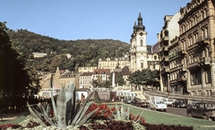 Csehország, Karlovy Vary, Vrídelní ulice a Termál Forrás kolonnád felé nézve, jobbra a Szent Mária-Magdaléna-templom., 1967, LHM, Csehszlovákia, templom, színes, park, utcakép, városkép, életkép, Moszkvics-márka, barokk-stílus, automobil, Skoda 1000 MB, rendszám, Volkswagen Bogár, székesegyház, gyógyszálló, Kilian Ignaz Dientzenhofer-terv, Fortepan #93512