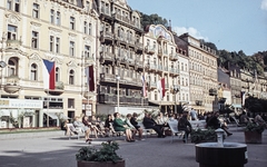 Csehország, Karlovy Vary, Mlynské nábrezí, balra a Vrídelní ulice., 1967, LHM, Csehszlovákia, színes, zászló, fodrászat, gyógyszálló, Fortepan #93515