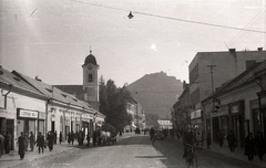 Ukraine,Zakarpattia Oblast, Khust, Karpatszkoji Szicsi utca (Rákóczi út) a főtér felől nézve, balra a Szent Anna-templom, háttérben a vár., 1939, Pálfi András, bicycle, church, horse, chariot, street view, castle ruins, cobblestones, church clock, Fortepan #93962