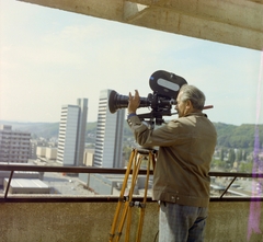 Magyarország, Salgótarján, filmforgatás a Fő téren álló Karancs Szálló tetejéről, háttérben a Rákóczi úti garzonházak. Schuller Imre operatőr, filmrendező., 1982, Schuller Judit, filmforgatás, színes, filmkamera, Arriflex-márka, Fortepan #94113