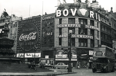 Egyesült Királyság, London, Piccadilly Circus, Shaftesbury Memorial Fountain, jobbra a Shaftesbury Avenue., 1957, Vaskapu utca, reklám, szobor, járókelő, utcakép, életkép, neonreklám, emeletes autóbusz, automobil, Fortepan #94476