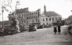 Magyarország, budai Vár, Budapest I., Szentháromság tér, szemben jobbra a Tárnok utca - Szentháromság utca sarkán a régi budai városháza, 1945, Fortepan, járműroncs, épületkár, Budapest, lámpaoszlop, nők, járókelő, fekete ruha, Fortepan #9806